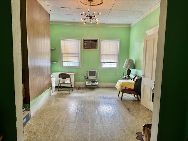 sitting room with hardwood / wood-style floors, a wall mounted air conditioner, and a notable chandelier