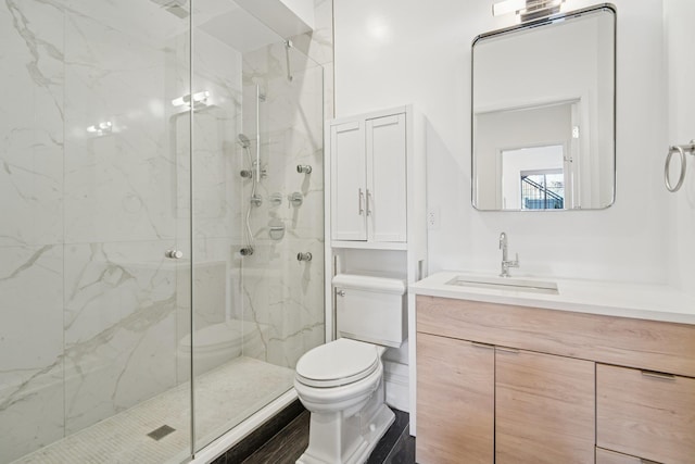 full bath with a marble finish shower, vanity, and toilet