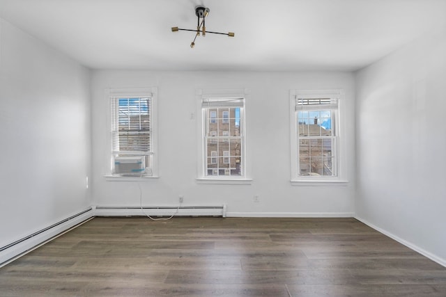 unfurnished room featuring a healthy amount of sunlight, a baseboard radiator, baseboards, and dark wood-type flooring