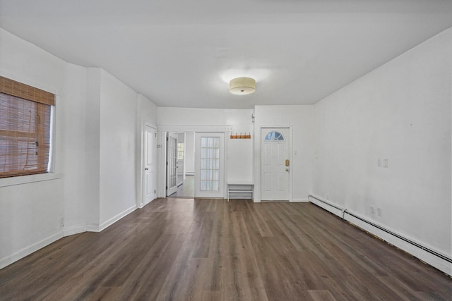 spare room with a baseboard heating unit, dark wood-style flooring, and baseboards