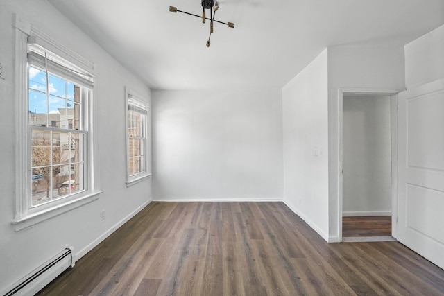 spare room with dark wood-style floors, a baseboard radiator, and baseboards