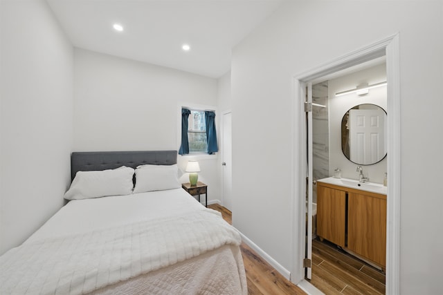 bedroom with connected bathroom, recessed lighting, a sink, baseboards, and light wood-type flooring