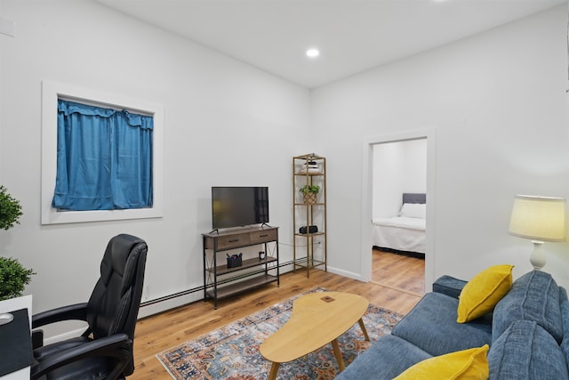 office space with a baseboard heating unit, recessed lighting, and wood finished floors