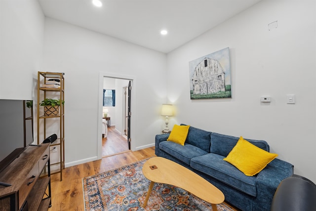 living room featuring baseboards, wood finished floors, and recessed lighting