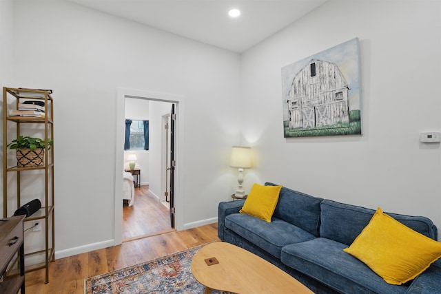 living area with baseboards, wood finished floors, and recessed lighting