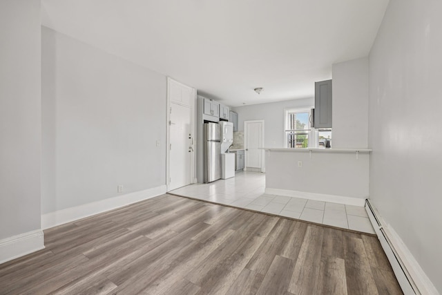 59 Monitor St Unit 3R, Jersey City, NJ 07304 - unfurnished living room with a baseboard radiator and light wood-style flooring