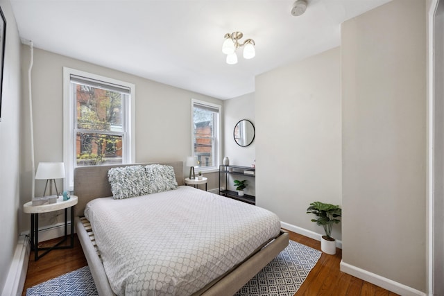 227 7th St, Jersey City, NJ 07302 - bedroom with baseboards, a baseboard heating unit, and wood finished floors