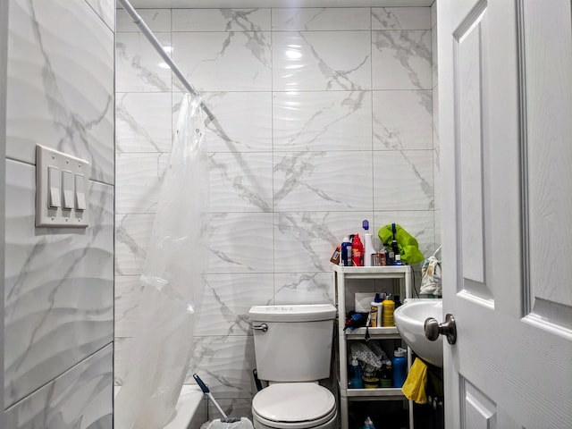 bathroom featuring toilet and tile walls