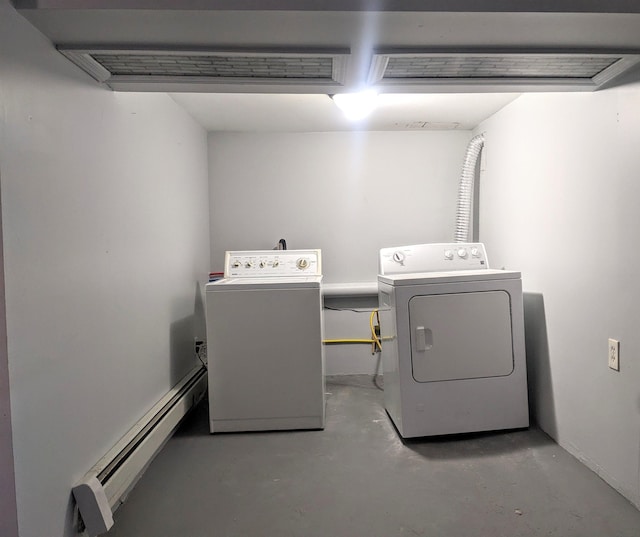 clothes washing area with washing machine and dryer and a baseboard heating unit