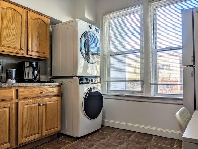 clothes washing area featuring stacked washing maching and dryer