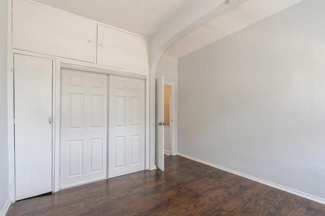 1109 12th St, North Bergen, NJ 07047 - unfurnished bedroom featuring arched walkways, dark wood finished floors, baseboards, and a closet
