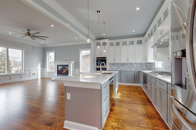 30 Cortland Pl, Cliffside Park, NJ 07010 - kitchen with a center island with sink, appliances with stainless steel finishes, a glass covered fireplace, a sink, and light wood-type flooring