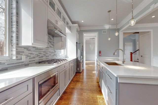 30 Cortland Pl, Cliffside Park, NJ 07010 - kitchen with under cabinet range hood, stainless steel appliances, a sink, light wood finished floors, and crown molding