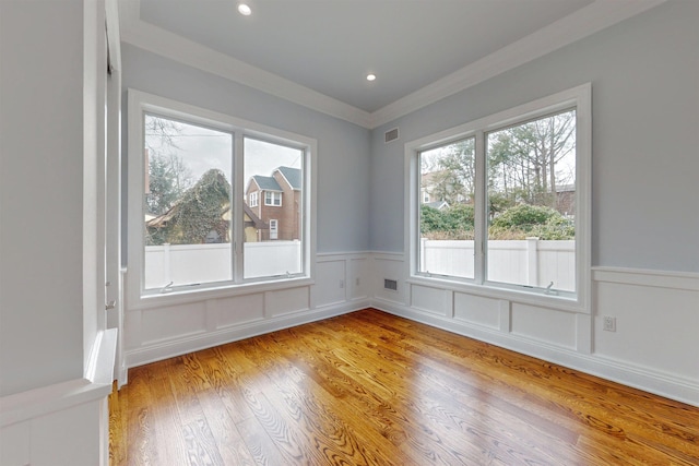 30 Cortland Pl, Cliffside Park, NJ 07010 - empty room with wainscoting, crown molding, a decorative wall, and light wood finished floors