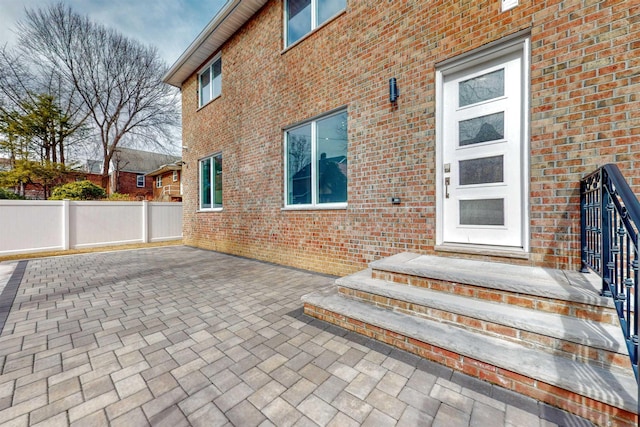 30 Cortland Pl, Cliffside Park, NJ 07010 - view of exterior entry with fence, a patio, and brick siding