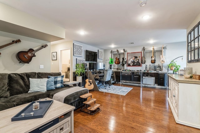 living room with hardwood / wood-style flooring and bar area