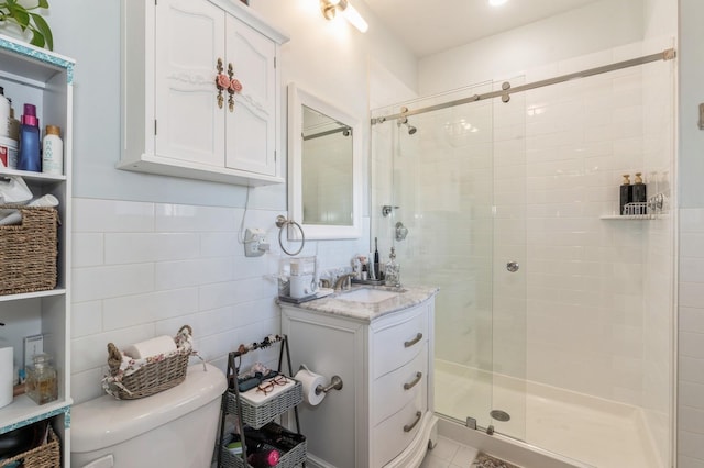 bathroom featuring walk in shower, vanity, toilet, and tile walls