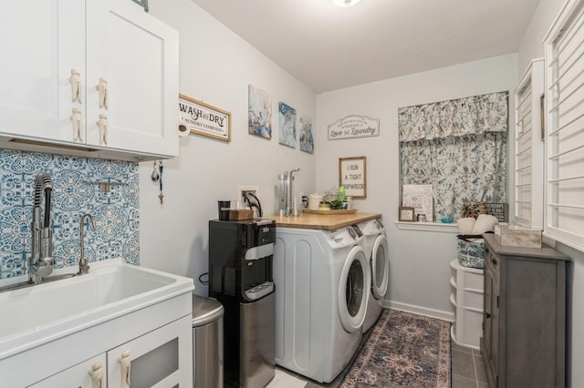 laundry room with cabinets, independent washer and dryer, dark tile patterned flooring, and sink