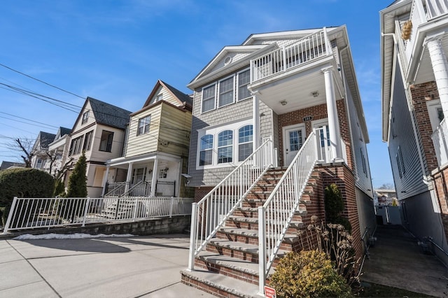 view of front of home with brick siding and stairway