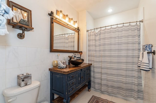 bathroom with tile walls, tile patterned flooring, a shower with shower curtain, vanity, and toilet