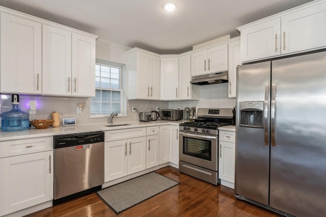 kitchen with dark wood-type flooring, sink, tasteful backsplash, stainless steel appliances, and white cabinets