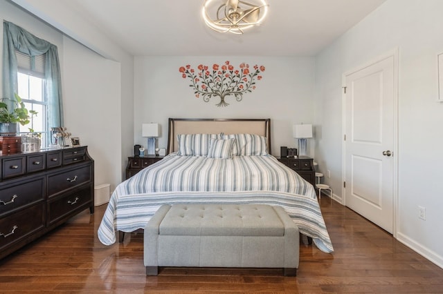 bedroom featuring dark hardwood / wood-style flooring and a notable chandelier