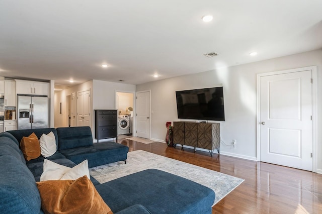 living room with hardwood / wood-style flooring and washer / clothes dryer