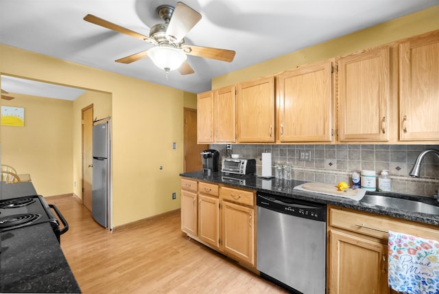 kitchen with stainless steel appliances, tasteful backsplash, a sink, and light brown cabinetry