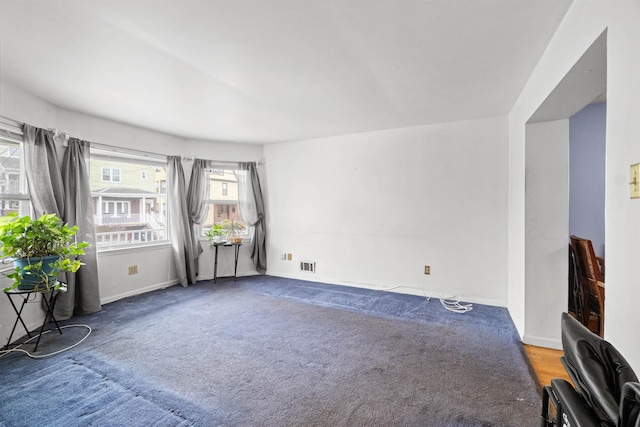 unfurnished room featuring carpet, visible vents, and baseboards