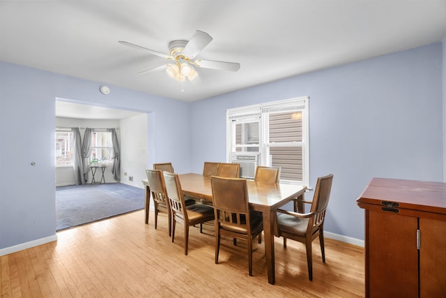 dining room featuring light wood finished floors, baseboards, and a ceiling fan