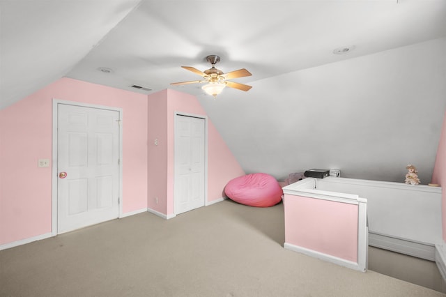 recreation room with carpet, lofted ceiling, visible vents, a ceiling fan, and baseboards