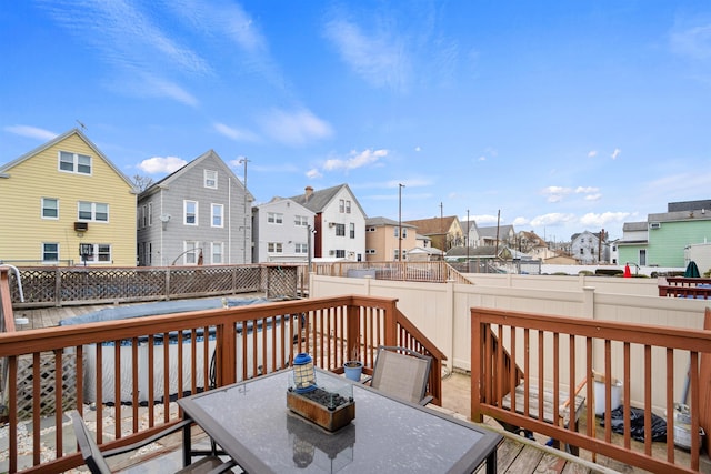 wooden deck with a fenced backyard, a residential view, and outdoor dining space