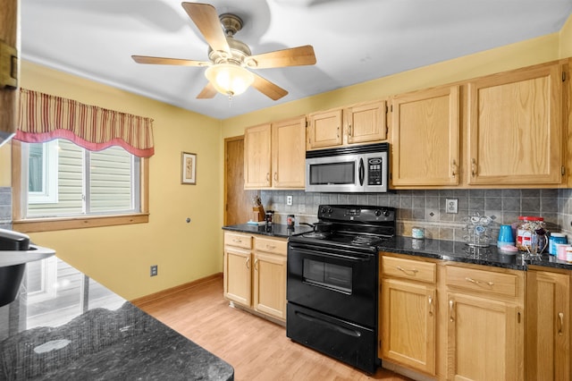 kitchen featuring black electric range, stainless steel microwave, backsplash, and light brown cabinetry