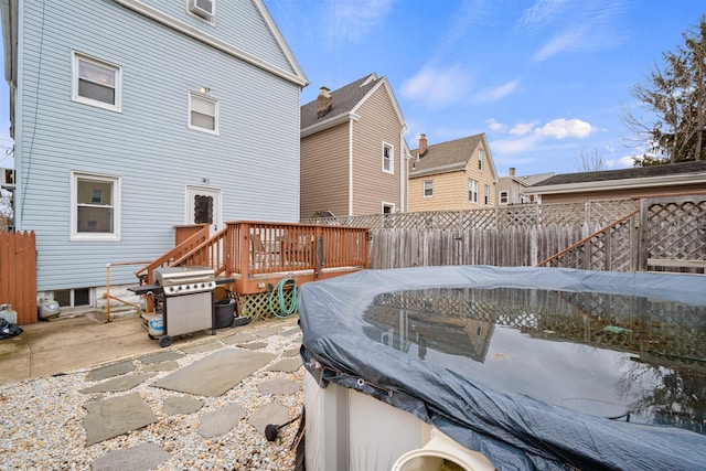 back of house with a patio area, fence, and a wooden deck