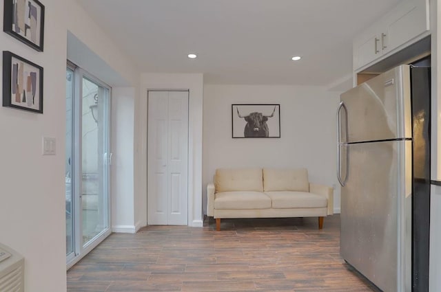 sitting room with baseboards, dark wood finished floors, and recessed lighting