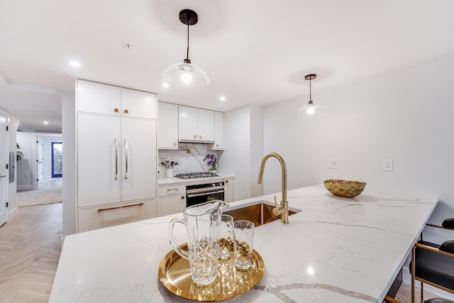 211 5th St Unit 1L, Jersey City, NJ 07302 - kitchen with stainless steel appliances, a sink, white cabinetry, decorative light fixtures, and recessed lighting