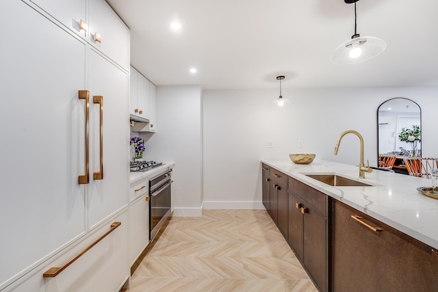211 5th St Unit 1L, Jersey City, NJ 07302 - kitchen featuring a sink, black oven, built in refrigerator, stainless steel gas cooktop, and white cabinetry