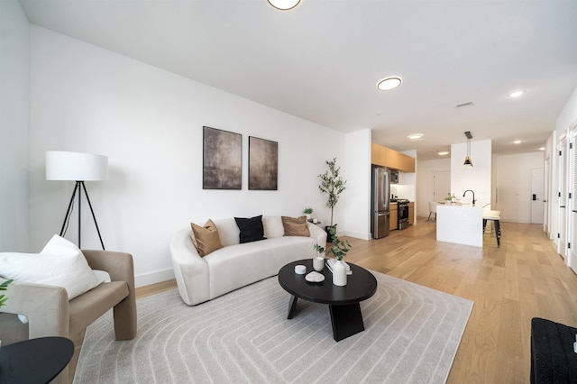 living room featuring sink and light wood-type flooring