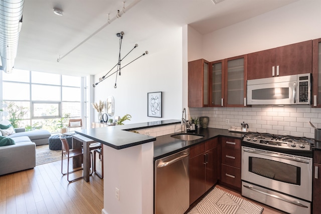 234 10th St Unit 606, Jersey City, NJ 07302 - kitchen featuring open floor plan, stainless steel appliances, a peninsula, dark countertops, and decorative backsplash