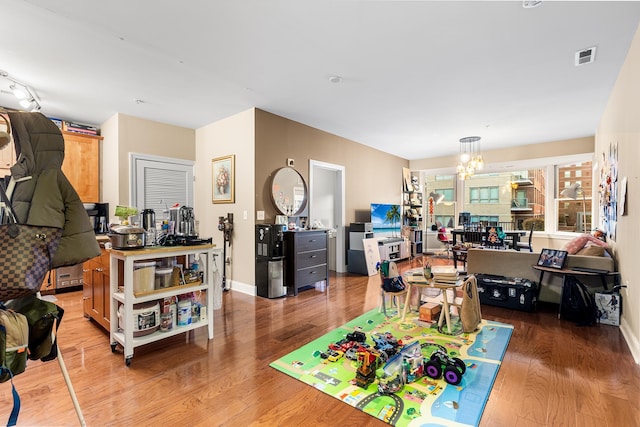 interior space featuring visible vents, a notable chandelier, and wood finished floors