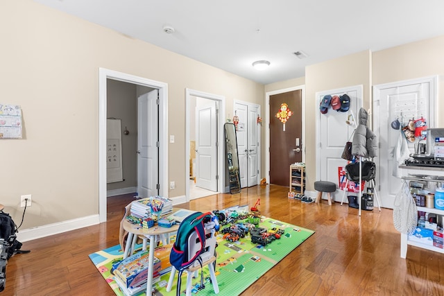 recreation room featuring wood finished floors and baseboards