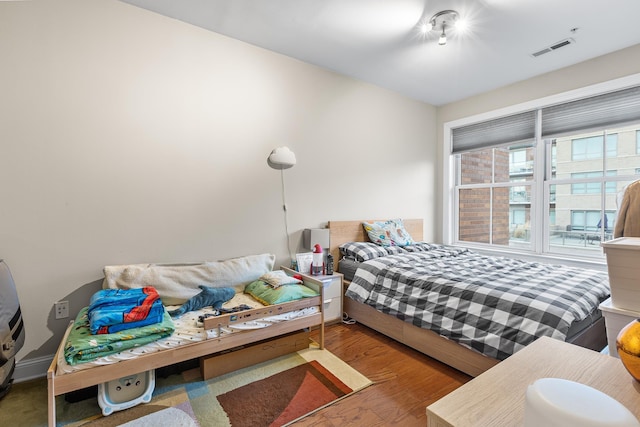 bedroom featuring visible vents and wood finished floors