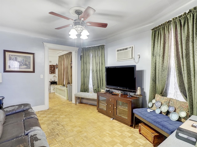 living room with an AC wall unit, a ceiling fan, and baseboards