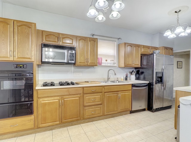 kitchen featuring a notable chandelier, a sink, light countertops, appliances with stainless steel finishes, and a warming drawer