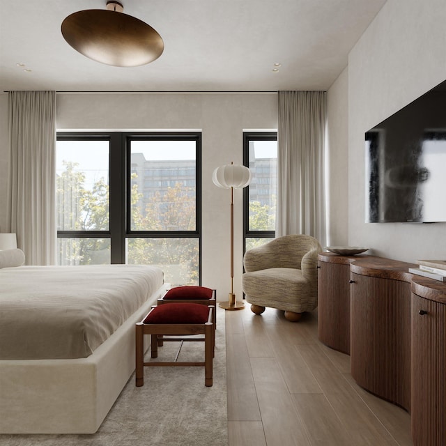 bedroom with multiple windows and light hardwood / wood-style floors