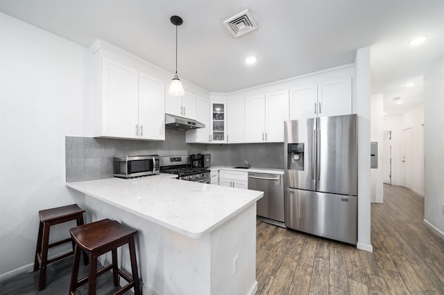 kitchen with white cabinetry, kitchen peninsula, hanging light fixtures, stainless steel appliances, and decorative backsplash