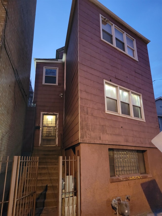 view of home's exterior with fence and stucco siding