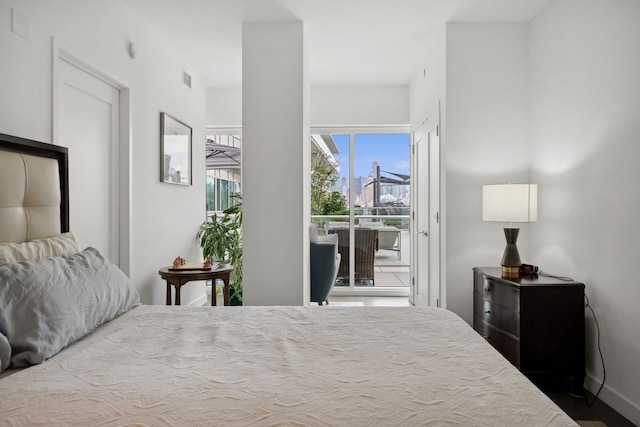 bedroom with wood-type flooring and access to outside