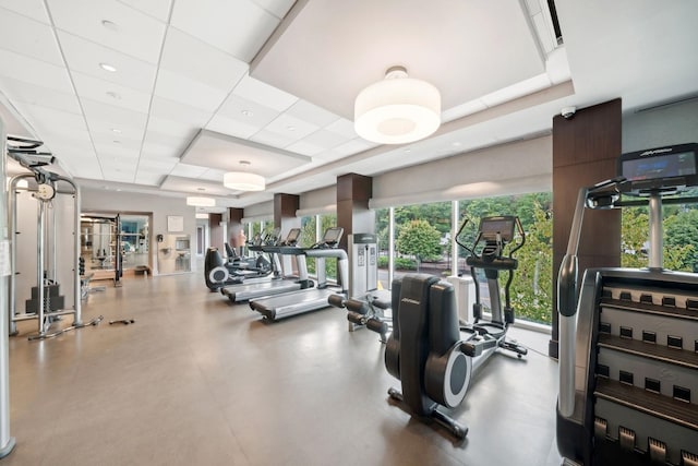 exercise room featuring a tray ceiling and a drop ceiling