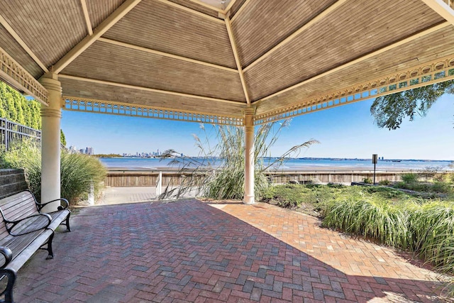 view of patio / terrace with a water view, fence, and a gazebo